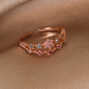 Macro shot of rose gold adjustable ring with multicolored gemstones on champagne satin