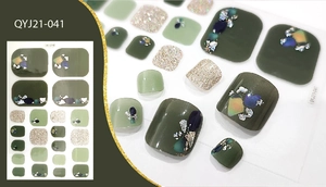 Detailed view of green and gold glitter toe nail stickers with rhinestones and foil