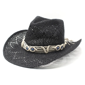 Handwoven black cowboy straw hat with bohemian Evil Eye beaded band on white background