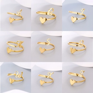 Collage of adjustable gold stainless steel rings with letter charms and heart detail