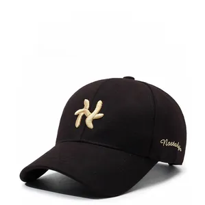 Detail of gold letter embroidery and premium cotton twill texture on a black baseball cap