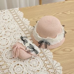 Détail du chapeau de paille rose et sac assorti avec volants blancs et nœud en dentelle