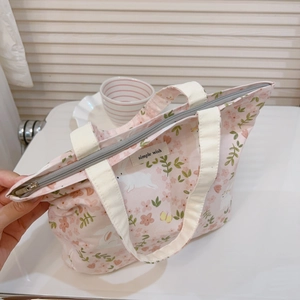 Detail der rosa geblümten Segeltuchtasche mit Hasenmuster, Reißverschluss und Stoffetikett