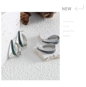 Detail of Korean-style geometric hoop earrings in green and grey enamel and silver titanium