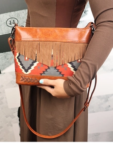 Detail of bohemian fringe crossbody bag with ethnic fabric pattern and brown PU leather