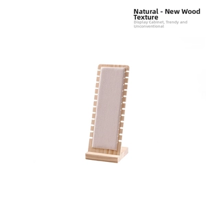 Macro detail of wooden necklace display stand with gray velvet lining and side notches
