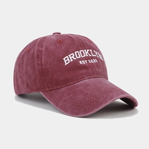 Close-up of white Brooklyn embroidery on washed burgundy cotton baseball cap