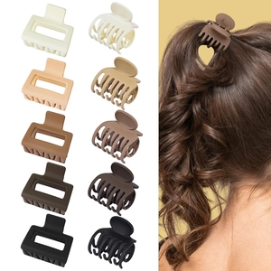 Close-up showing various plastic hair claw clips in neutral tones and model styling