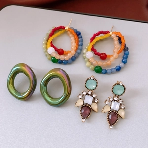Detail of vintage style earrings featuring rhinestone accents and glass water drop charms