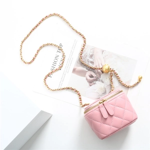 Macro detail of the pink quilted leather cosmetics bag with gold chain and ball adjuster