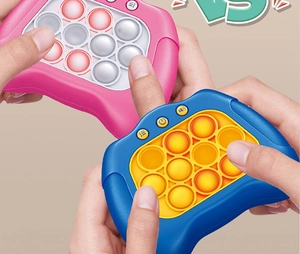 Close-up of pink and blue electronic pop puzzle game consoles being played by hands