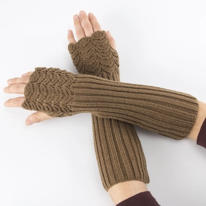 Close-up of brown knitted arm warmer with wave pattern and fingerless thumb hole