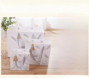 Elegant white paper gift bags with silver feather prints and grey satin ribbon handles