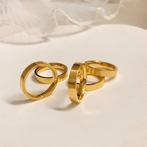 Classic matte 18k gold plated stainless steel rings for men and women on white surface