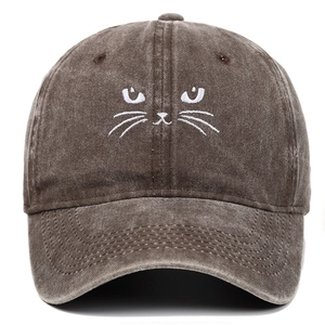 Close-up of white cat face embroidery on dark brown washed cotton baseball cap