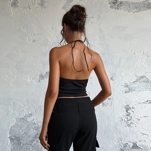 Détail d'un haut dos nu noir avec design à nouer et arrière-plan de style industriel