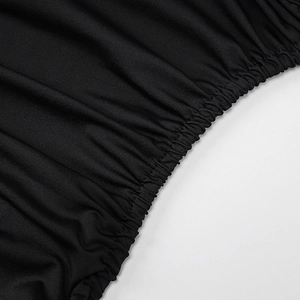 Detail of elegant black dress showing high-quality ruching and elastic gathered fabric