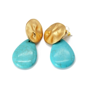 Detail view of golden hammered metal discs and turquoise-style teardrop pendants