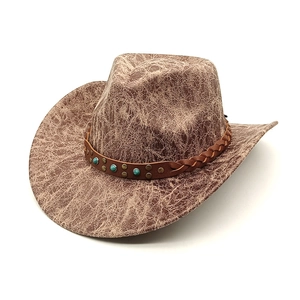 Dettaglio cappello da cowboy marrone con trama vintage screpolata e cinturino in pelle perlato