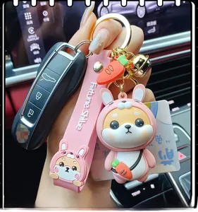 Detail of pink rabbit costume Shiba Inu keychain with lucky bell and carrot charm on car key