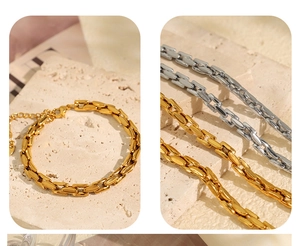 Detailed close-up of gold and silver polished cuban chain bracelets on stone base