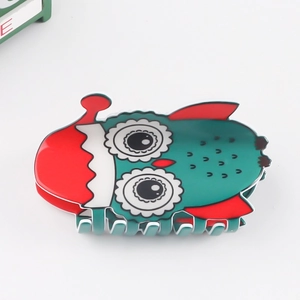 Gros plan sur une pince à cheveux chouette festive aux couleurs vert, rouge et blanc