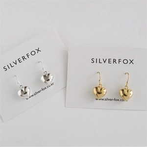 Detail of silver and gold heart earrings on cards showing mirror-polished finish