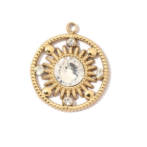 Detail of a golden sunburst coin pendant with white rhinestones and beaded border