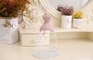 Detail of pink mannequin jewelry stand with lace trim and white metal hooks for necklaces