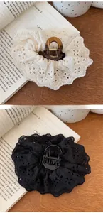 Close-up of elegant French lace embroidery hair claw clips in black and beige colors