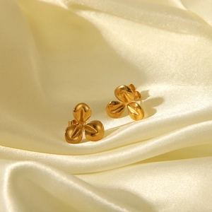 Vue détaillée de boucles d'oreilles fleur 18k dorées sur fond satiné pour luxe élégant