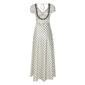Dettaglio dell'abito bianco a pois schiena scoperta con pizzo nero e scollo a V