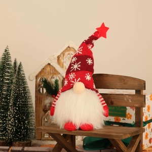 Lighted Christmas gnome plush on wooden bench with festive red and white knit design