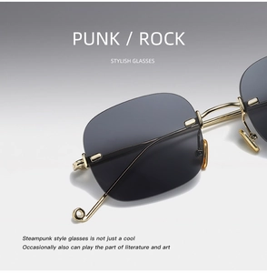 Close-up of rimless steampunk sunglasses with gold metal temples and grey lenses