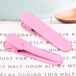 Detail shot of two pink seamless hair clips with a smooth matte finish on a clean background