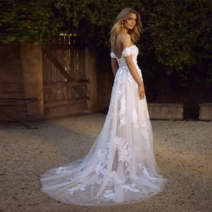 Elegant off-shoulder white lace wedding dress with floral appliques and a long train