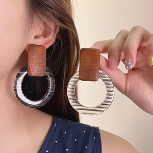 Close-up of retro wood and striped acrylic round drop earrings shown on model's ear