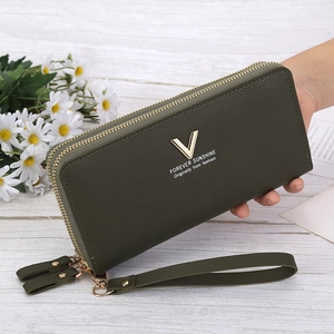 Close-up of a green double-zipper wallet featuring lychee texture and golden V hardware