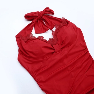 Detail of red backless halter dress with lace trim and pleated elastic fabric texture