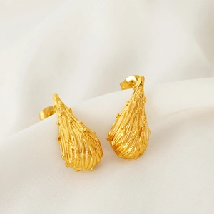 French style teardrop gold earrings with textured surface on white silk background