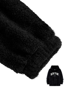 Detail van zwarte hoodie met zachte fleece textuur en New York geprinte letters