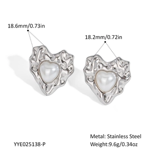 Detail of silver heart earrings with pearl inlay and textured stainless steel edges