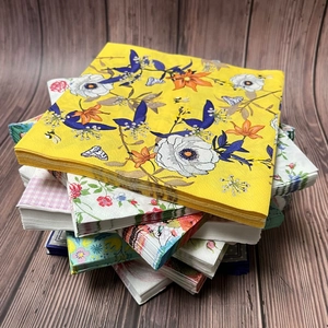 Floral printed paper napkins with assorted colorful patterns on a dark wood background