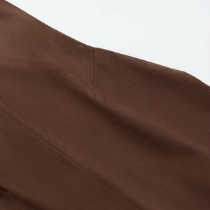 Gros plan sur la texture en daim marron foncé et les détails de couture du gilet