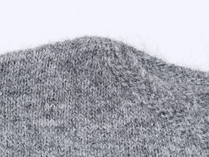 Gros plan sur un tissu en maille grise montrant la texture douce de la laine