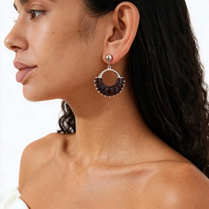 Vintage geometric leather earrings with silver circular design and rivet details on model