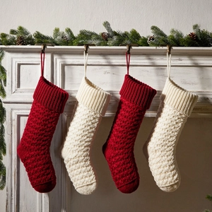 Classic red and cream cable knit Christmas stockings hanging on a festive mantel