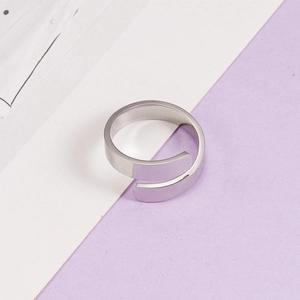 Macro detail of silver crossover wrap ring with a polished minimalist open design