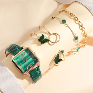 Detail of square vintage watch with emerald strap and butterfly jewelry set in rose gold