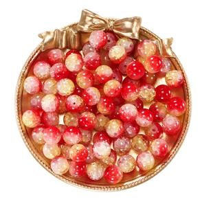 Close-up of 10mm red and gold cracked glass beads displayed in a golden bow tray